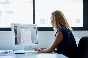 a woman looking at a computer monitor